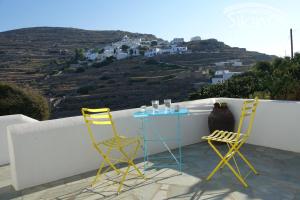 two chairs and a table on a balcony with a view at Sikinos Elegant Studio in Sikinos