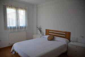 ein Schlafzimmer mit einem weißen Bett mit einem Kissen darauf in der Unterkunft Casa Miruetxe in Lekunberri + 11 Fotos