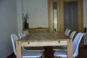 einen Esstisch mit weißen Stühlen um ihn herum in der Unterkunft Casa Miruetxe in Lekunberri
