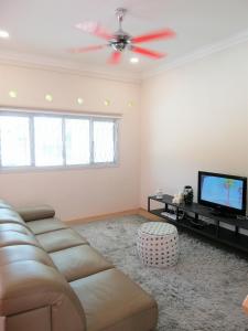 ein Wohnzimmer mit einem Sofa und einem Flachbild-TV in der Unterkunft Klebang Seacove Villa by Nestcove in Malakka