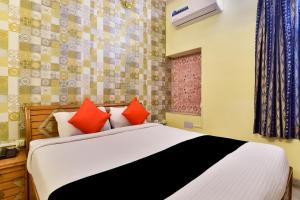 um quarto com uma cama com almofadas vermelhas em Hotel Radoli House - A Heritage Hotel em Jaipur