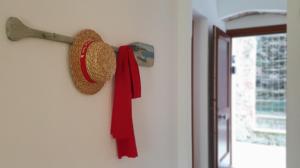 a hat and a red scarf hanging on a wall at Arbanella in Corniglia