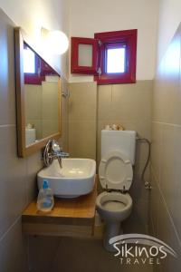 a bathroom with a toilet and a sink and a mirror at Anna's House in Síkinos