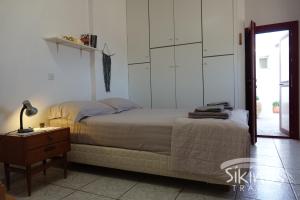 ein Schlafzimmer mit einem Bett, einem Tisch und einer Lampe in der Unterkunft Anna's House in Síkinos