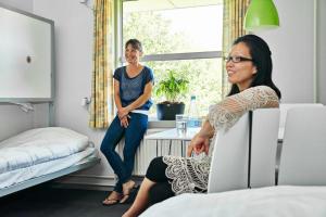 two women standing in a room with a bed at Danhostel Hobro in Hobro