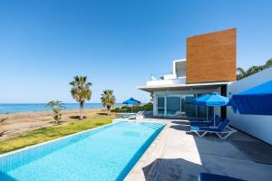 eine Villa mit einem Pool am Meer in der Unterkunft Seafront Villa Sea Gem - Private Beach Area & Infinity Pool in Polis Chrysochous