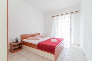 Selca的住宿－Apartments Neva，一间卧室配有一张带红色毯子的床和窗户。