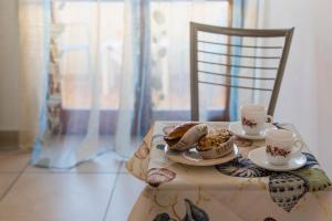 a table with two cups and plates of food on a chair at le terrazze sul mare gallipoli in Gallipoli +32 photos