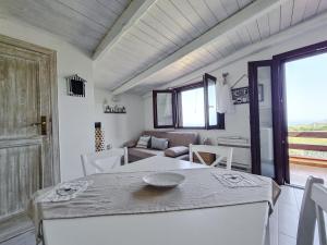カステルサルドにあるAppartamento La Palmaの白い部屋(テーブル、椅子、ソファ付)