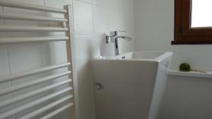 a white bathroom with a sink and a faucet at La Maison Cent 5 avec parking privé in Saint-Valery-sur-Somme +29 photos