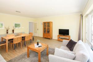 a living room with a couch and a table at Strandhaus Helene in Wenningstedt