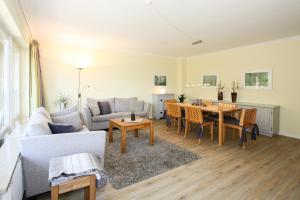a living room with a couch and a table at Strandhaus Helene in Wenningstedt