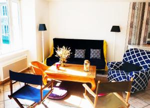 uma sala de estar com uma mesa e um sofá em Maison de La Beslière meublé de tourisme 2 étoiles em Folligny
