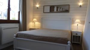 a bedroom with a bed and two lamps on tables at La Maison Cent 5 avec parking privé in Saint-Valery-sur-Somme