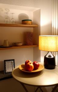 two apples on a plate on a table with a lamp at Arbanella in Corniglia