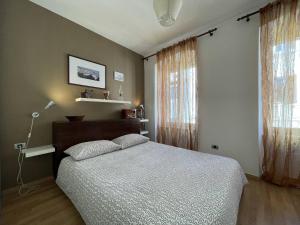 een slaapkamer met een bed en een lamp en twee ramen bij Apartment Igor in Pula