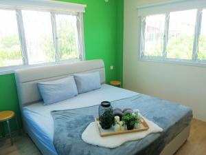 1 dormitorio con 1 cama con paredes y ventanas verdes en Klebang Seacove Villa by Nestcove, en Melaka