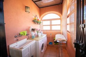 a bathroom with a washing machine and a sink at Arenda Villa Rosa in Hospitalet de l'Infant