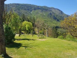 un tavolo da picnic in un parco con montagne sullo sfondo di Camping Calme et Nature a Castellane