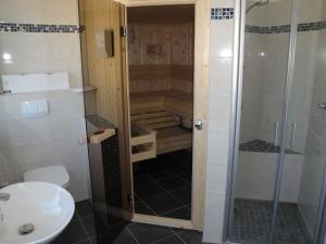 a bathroom with a shower and a toilet and a sink at Ostsee Strandvilla Silvia in Lobbe +26 photos