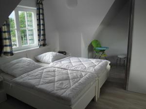 a white bed in a room with a window at Ostsee Strandvilla Silvia in Lobbe