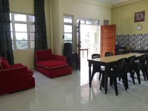 ein Wohnzimmer mit einem Esstisch und Stühlen in der Unterkunft VILLA SENTOSA in Kuala Terengganu