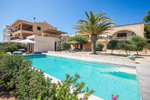 a large swimming pool in front of a house at Villa Cabrera loft in Colonia Sant Jordi