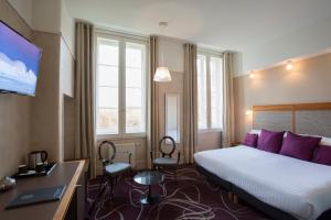 A bed or beds in a room at Hôtel de Normandie