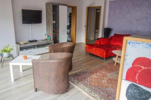 a living room with a red couch and a table and chairs at Ferienwohnung Habermehl in Oppenau