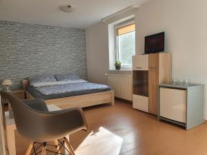 une chambre avec un lit et une chaise dedans dans l'établissement Willa SOL, à Mielno