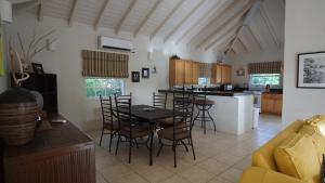a kitchen and living room with a table and chairs at Luxury secluded villa with private pool sleeps six in Jolly Harbour