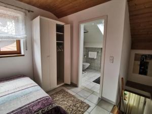 a bedroom with a bed and a bathroom at Ferienappartement Stutz in Neukirchen am Teisenberg