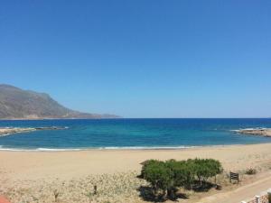 a sandy beach with trees and the ocean at Gramvoussa Bay in Kissamos