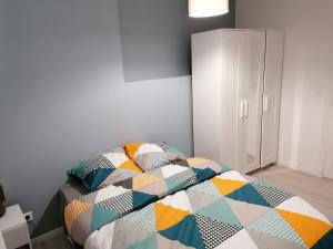 a bedroom with a bed with a colorful quilt at SWEET Appartment avec Wifi et parking in Clermont-Ferrand