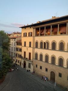 a large building with people sitting on a street at Hotel Palazzo Guadagni in Florence