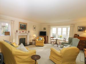 a living room with yellow chairs and a fireplace at Samstone in Shaftesbury