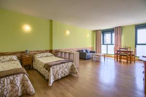 a hotel room with two beds and a living room at Apartamentos Barajas in Madrid