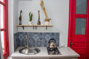 een keuken met een wastafel en een rode deur bij Check Point Hotel in Tbilisi City