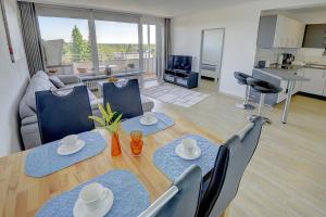 un soggiorno con tavolo e sedie e una cucina di Haus Weitblick Ole a Flensburgo
