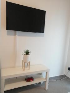 a living room with a tv on a white wall at Apartment OG in Oststeinbek
