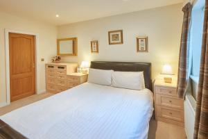 a bedroom with a bed and a dresser and a mirror at Host & Stay - Folkton Cottages in Scarborough