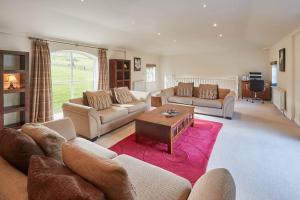 a living room with couches and a table at Host & Stay - Folkton Cottages in Scarborough