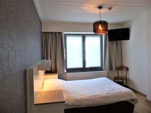 a bedroom with a white bed and a window at Logis Hotel Du Midi in La-Roche-en-Ardenne