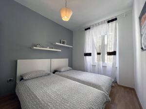 een slaapkamer met 2 bedden en een raam bij Apartment Igor in Pula