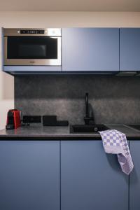 a kitchen counter with a microwave and a dishwasher at ROXI Residence Gent in Ghent