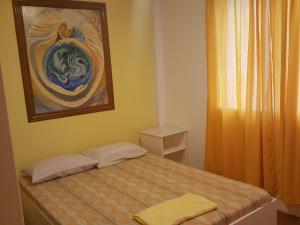 un pequeño dormitorio con una cama y una pintura en la pared en Citadel Alona Inn en Panglao