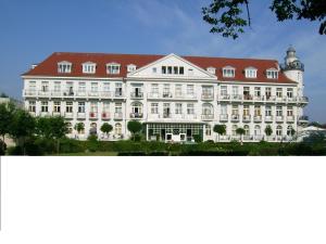a large white building with a red roof at Ferienwohnungen am Rosenhof in Kühlungsborn