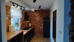 a kitchen with a sink and a brick wall at Sopot Noclegi in Sopot