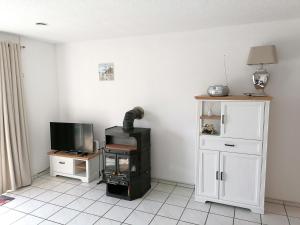 a living room with a stove and a tv at Ferienhaus Rudi in Frankenau