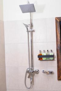 a shower with a shower head in a bathroom at Burka Coffee Lounge in Arusha